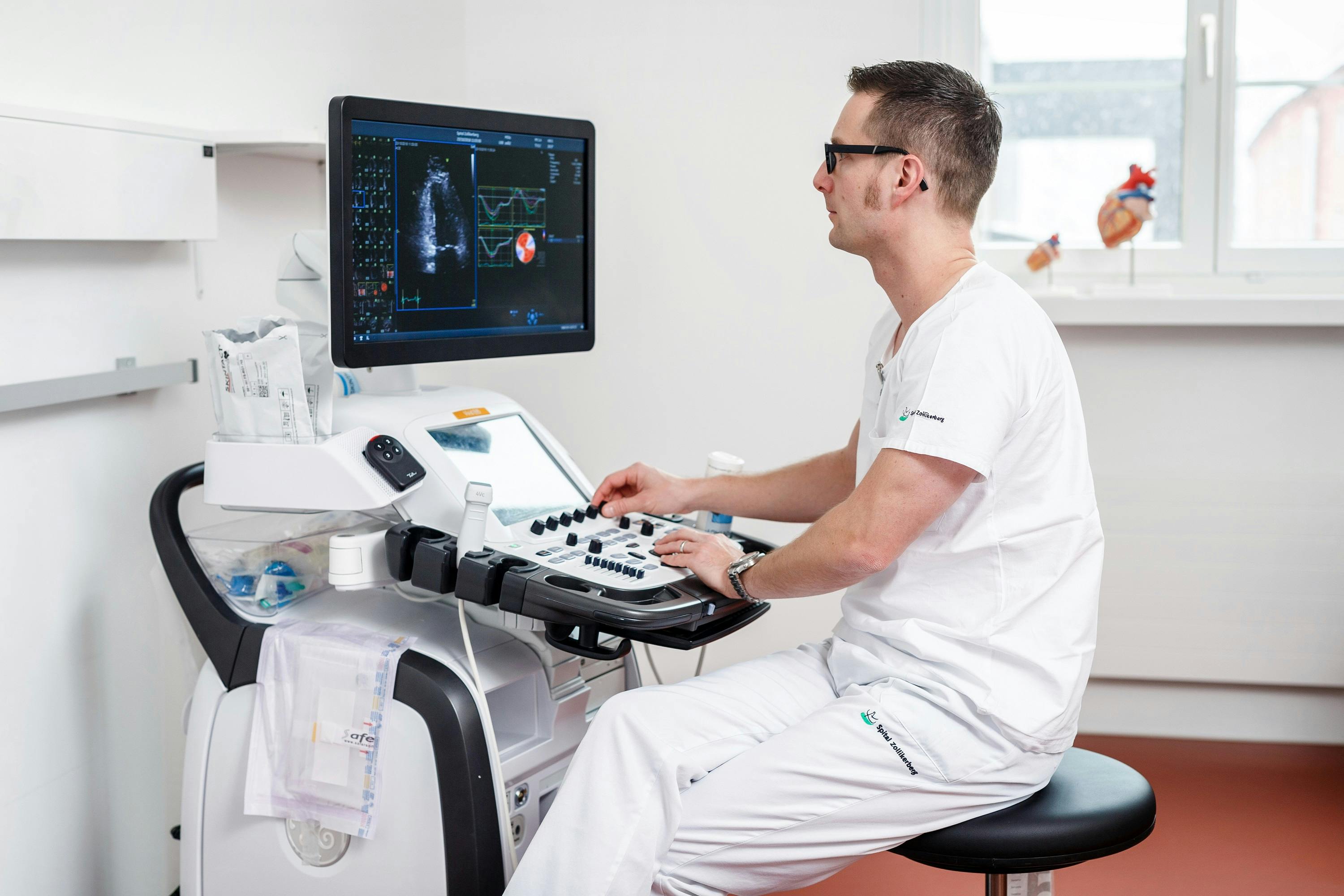 Medical professional operating an ultrasound machine in a clinic.