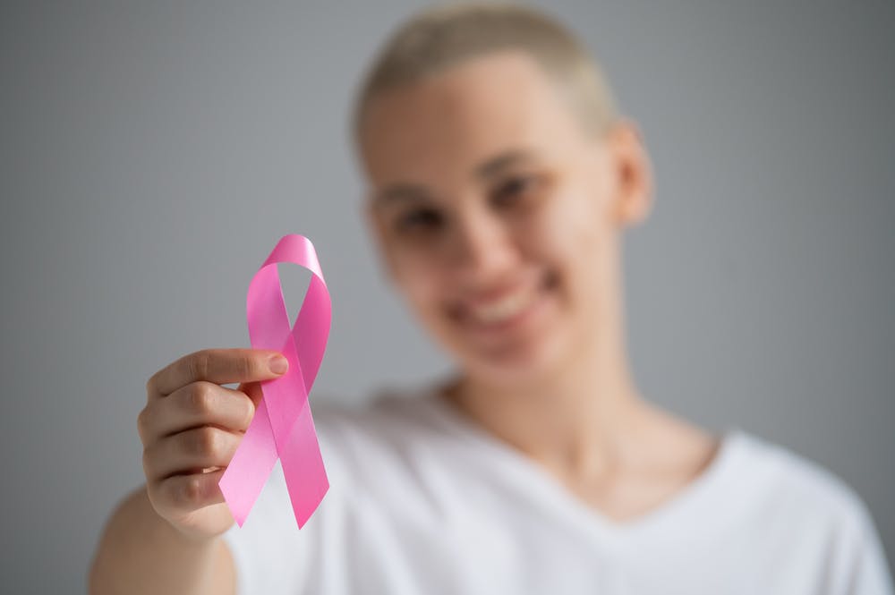 Woman with pink breast cancer awareness ribbon.