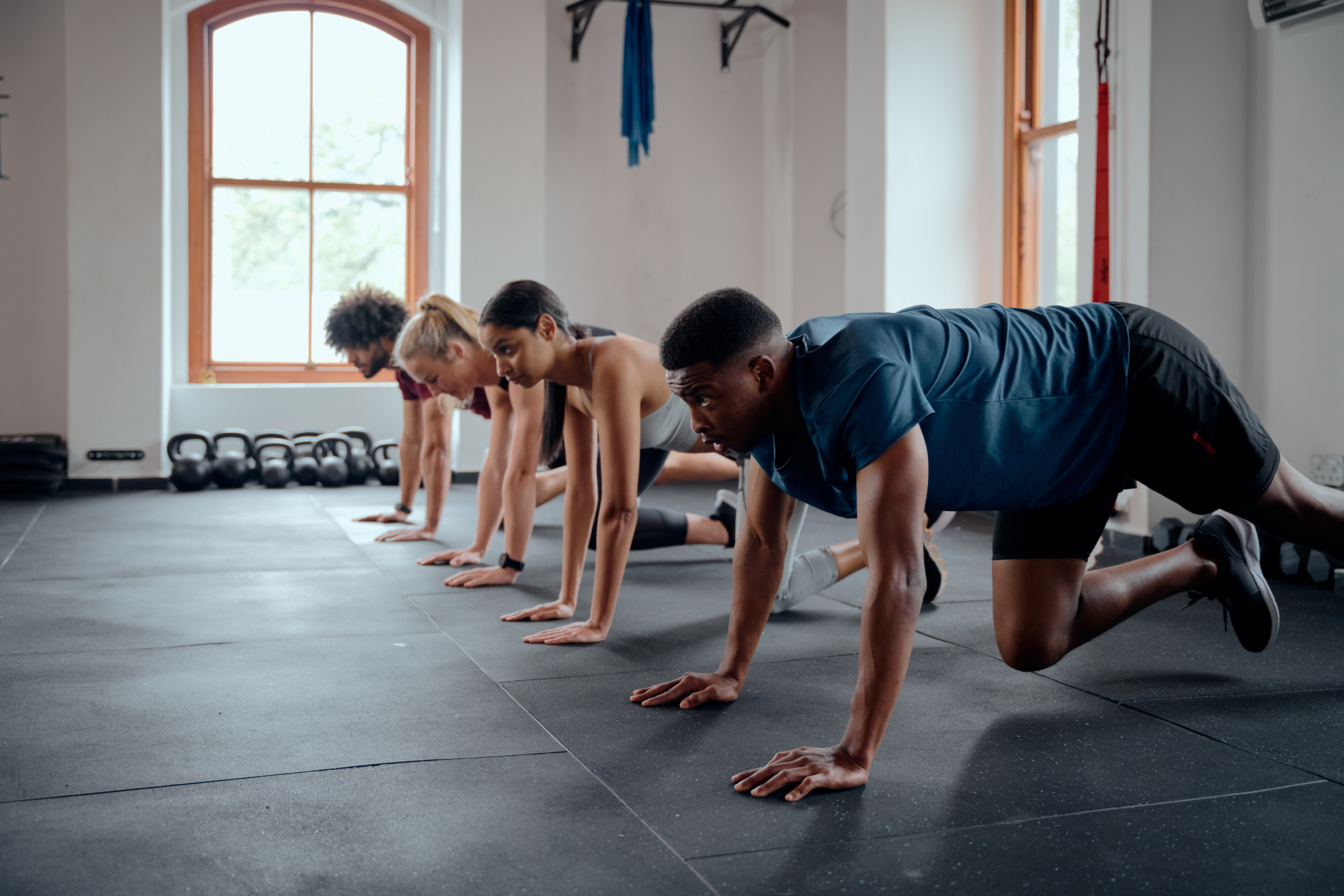 Group of people doing push-ups in the gym.