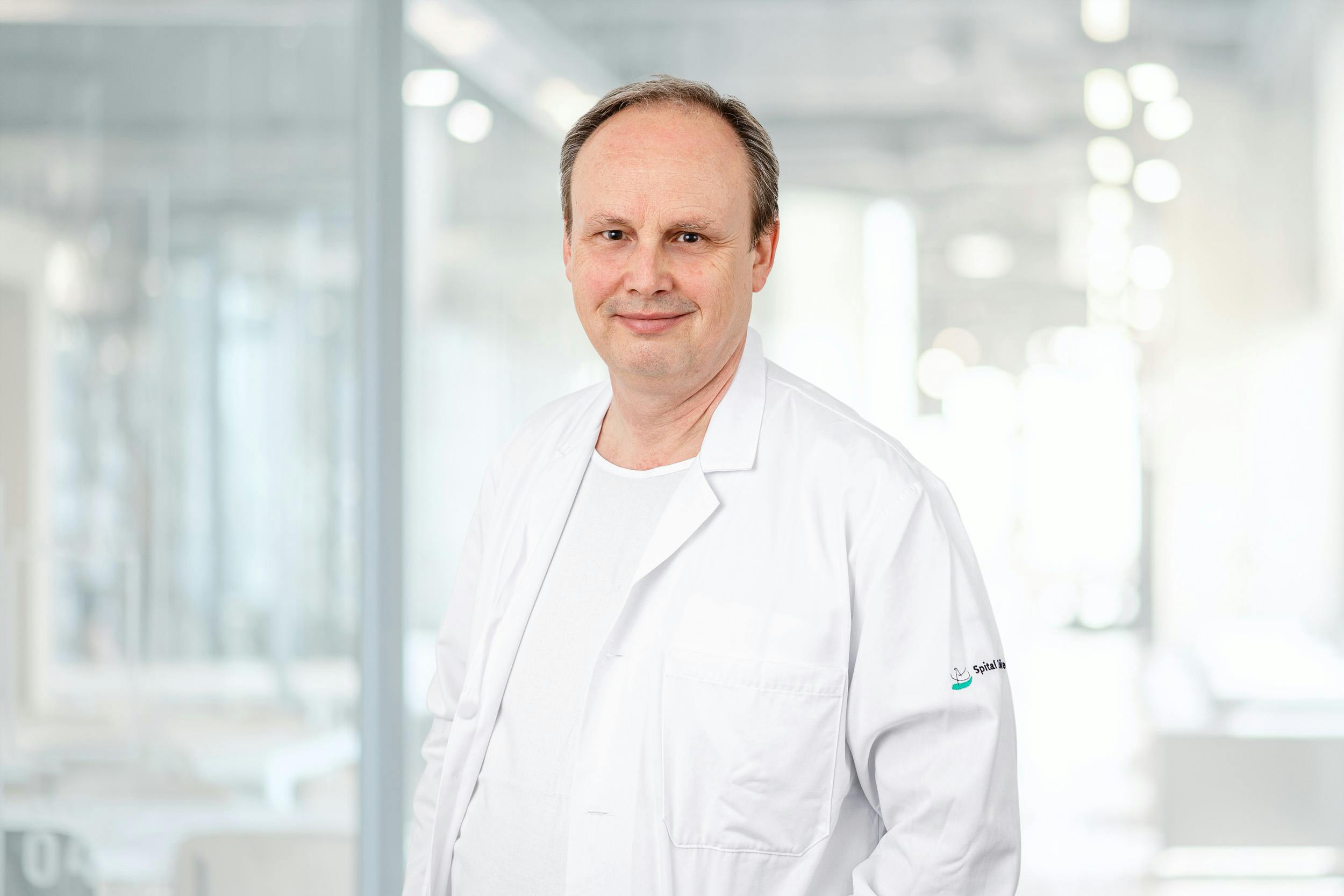 Dr Stephan Müller in a white coat against a blurred background.