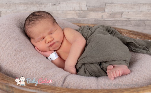 Neugeborenes schläft in einem Korb auf einer weichen Decke.