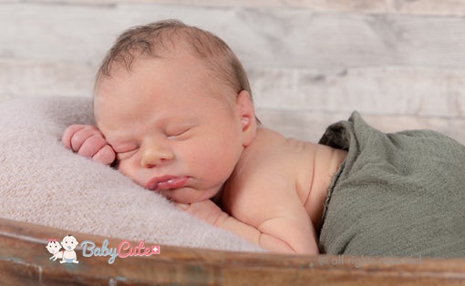Sleeping newborn on a soft surface.