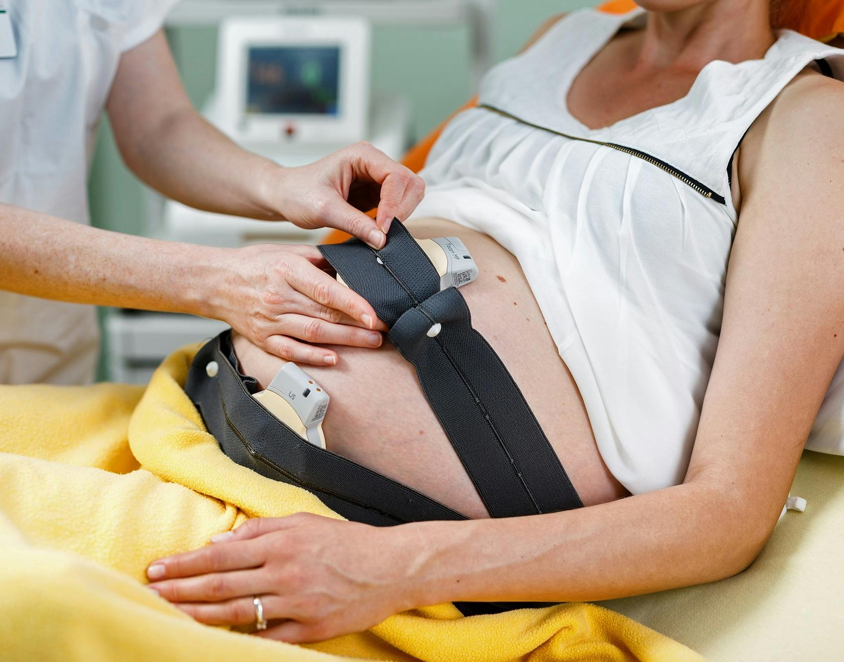 Schwangere Frau mit CTG-Gürteln zur Überwachung der fetalen Herzfrequenz im Krankenhaus.