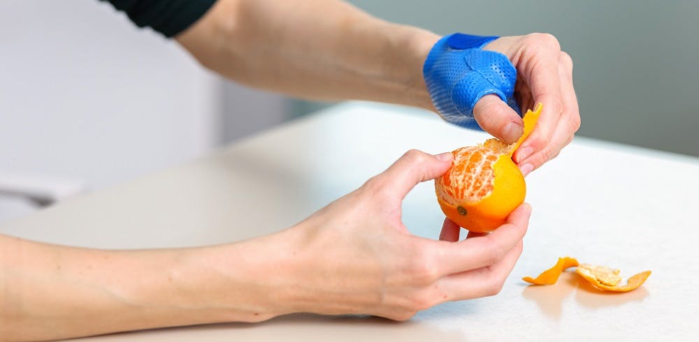 Person peels a mandarin with a kitchen glove