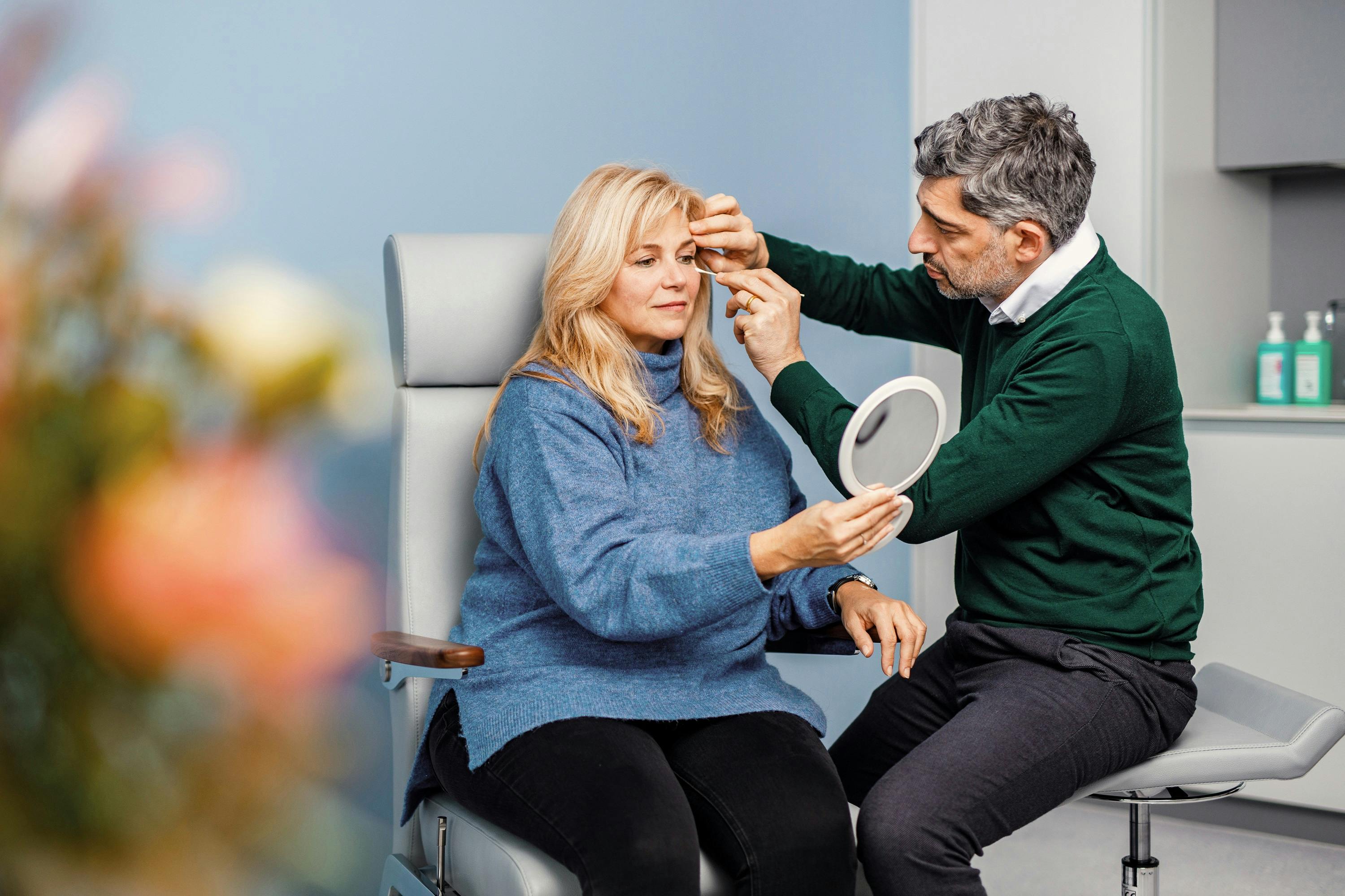 Plastic surgeon examines patient in Zurich beauty clinic.