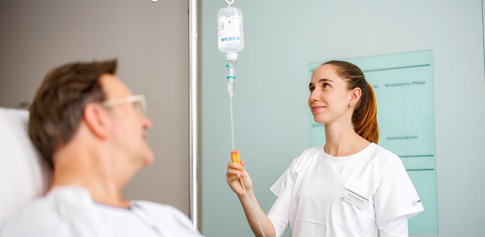 Nurse monitoring an infusion in a hospital environment.